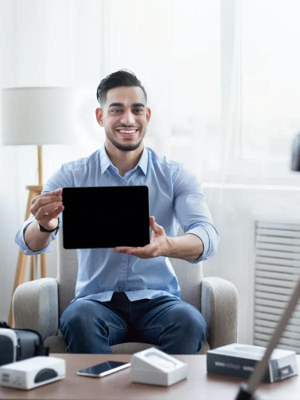 arab-male-influencer-shooting-video-review-of-modern-tablet-computer-on-professional-dslr-camera-at